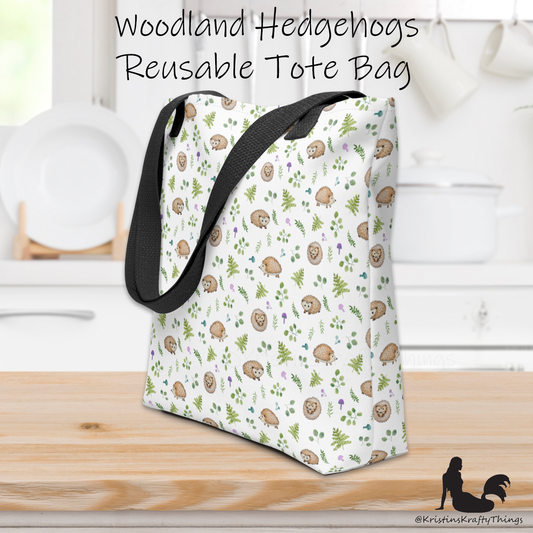 All-over full color print from original watercolor painting. These adorable woodland hedgehogs dance about with green ferns and purple &amp; teal mushrooms on this spacious tote bag to help you carry around everything that matters. Photo of tote bag on counter top.