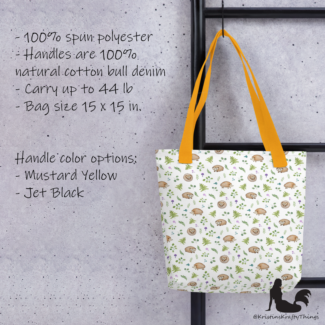 All-over full color print from original watercolor painting. These adorable woodland hedgehogs dance about with green ferns and purple &amp; teal mushrooms on this spacious tote bag to help you carry around everything that matters. Photo of tote bag with yellow handle with details about the bag.